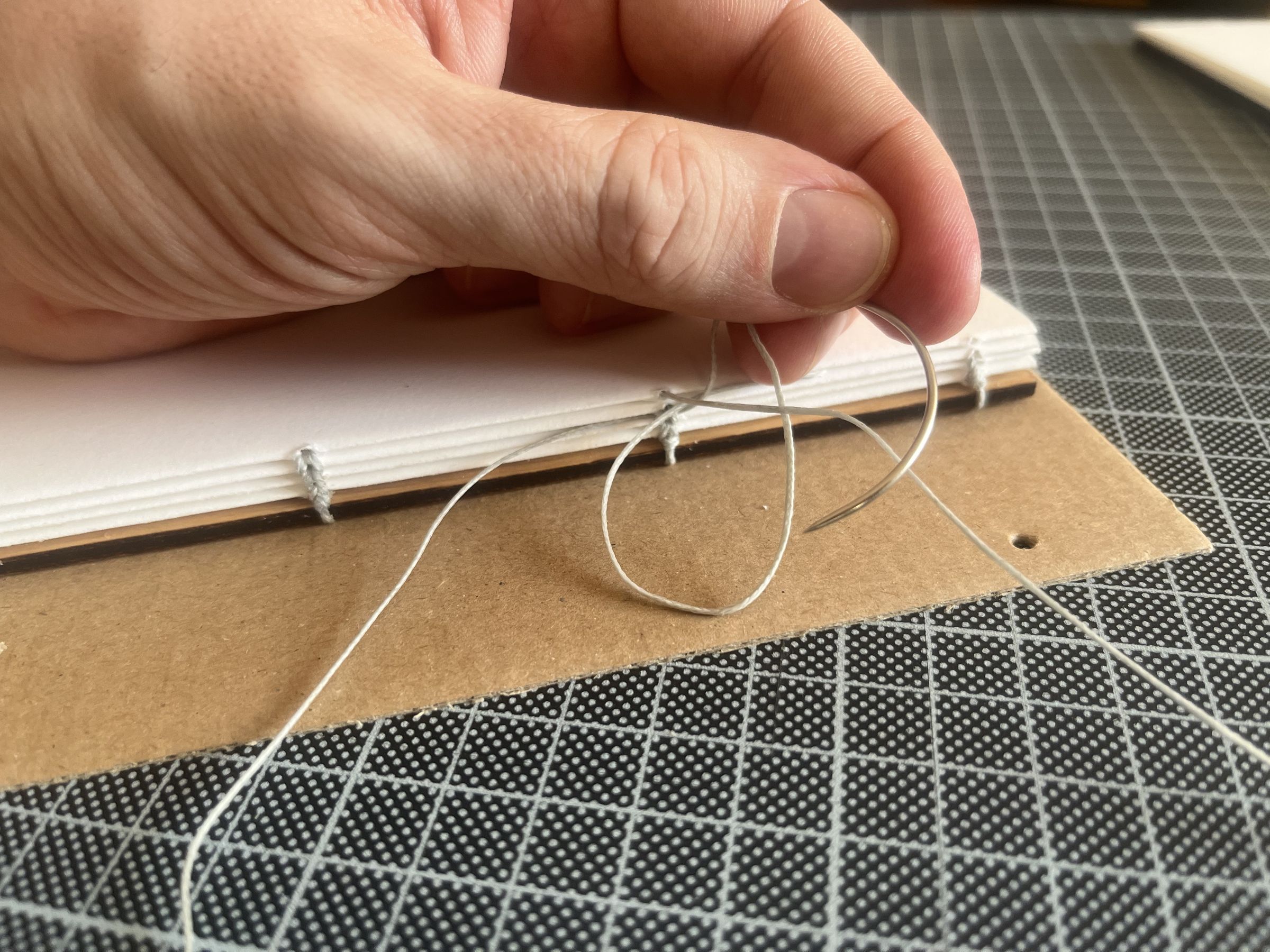 Binding the album with waxed thread